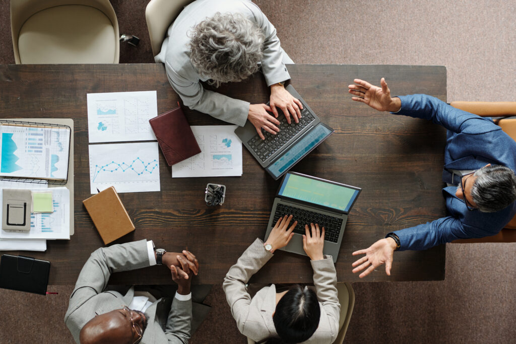 Diverse middle-aged business professionals collaborating in a modern office during a team meeting.