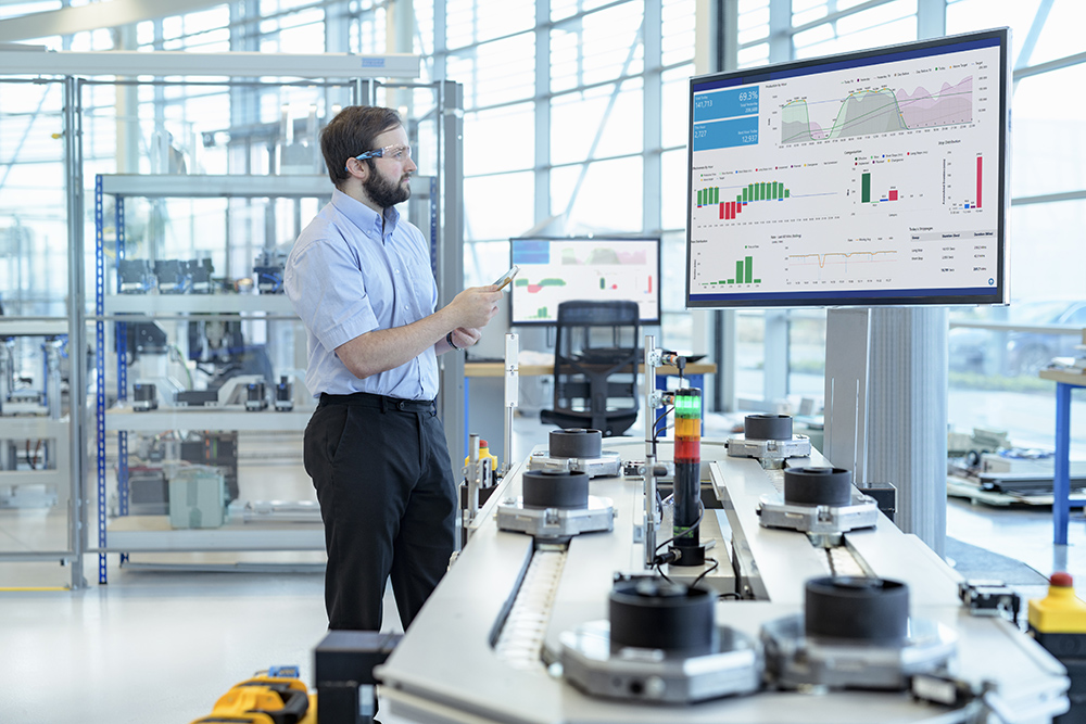 A male engineer analyzing data on the factory floor.