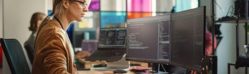 Caucasian,Woman,Coding,On,Desktop,Pc,And,Laptop,Setup,With